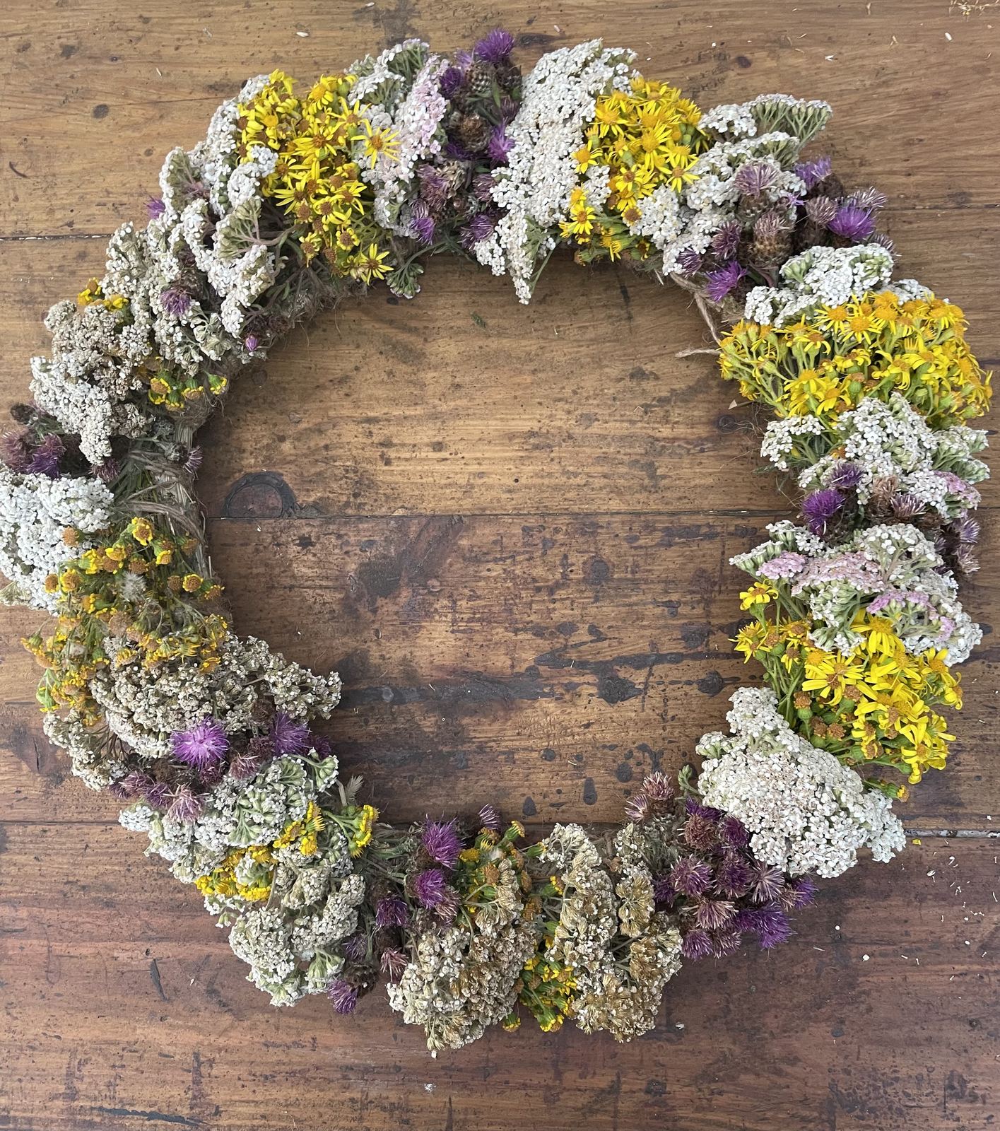 Handmade dried wildflower wreath on a wooden background